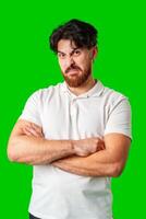 A man makes a funny face while posing against a bright green background photo