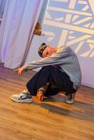 A dancer performs a move in a studio, showcasing their flexibility and control photo