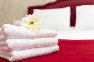 Stack of towels with flower decor in a hotel room photo