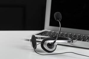 call center support concept. headset on keyboard computer laptop photo