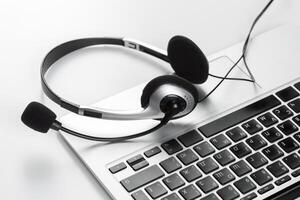 call center support concept. headset on keyboard computer laptop photo