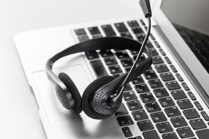 call center support concept. headset on keyboard computer laptop photo