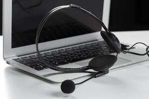 call center support concept. headset on keyboard computer laptop photo