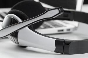 call center support concept. headset on keyboard computer laptop photo