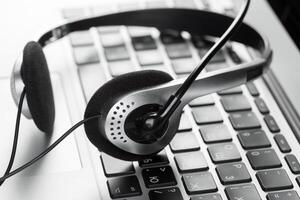 call center support concept. headset on keyboard computer laptop photo