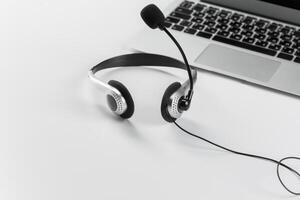 call center support concept. headset on keyboard computer laptop photo