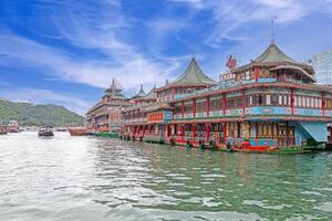 Colorful floating restaurant with intricate Asian architecture on a scenic waterfront under a vibrant sky photo