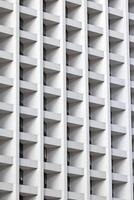 Modern high-rise facade with repeating geometric balconies creating a minimal and abstract urban pattern photo