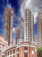 Dense urban architecture in Hong Kong with tightly packed high-rise buildings under a bright sky photo