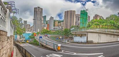 Dense urban architecture in Hong Kong with tightly packed high-rise buildings under a bright sky photo