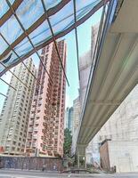 Dense urban architecture in Hong Kong with tightly packed high-rise buildings under a bright sky photo