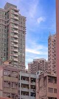 Dense urban architecture in Hong Kong with tightly packed high-rise buildings under a bright sky photo