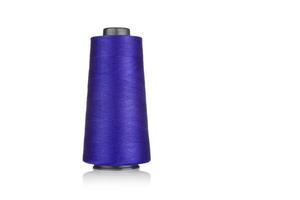 spool of industrial threads purple colors, texture of threads on a white background close-u photo