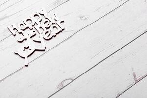 beautiful branches of a Christmas tree with cones and toys on a white wooden background with the inscription Happy New Year photo