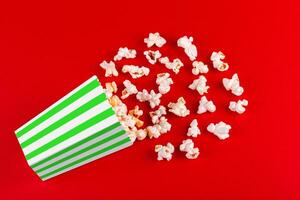 box with popcorn striped in different colors on a red background photo