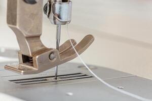 Sewing machine needle with thread and fabric photo
