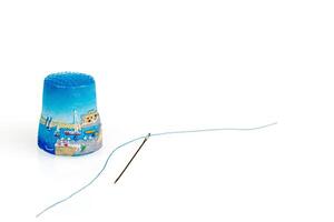 thimble and needle and thread on a white background photo
