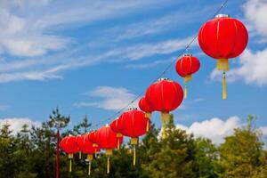 Red Chinese Paper Lanterns against a Blue Sky photo