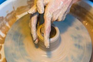 womens hands of a potter creating an earthen jar photo