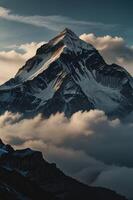 A mountain is seen in the clouds with snow on top photo
