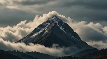 A mountain is covered in clouds and trees photo