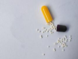 Capsules and granules of omeprazole isolated on white background photo