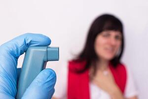Doctor keeps asthma inhaler with salbutamol, in the background is a girl who is suffocating asthma, bronchodilator medications, budesonide photo