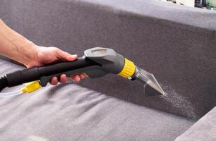Applying a special cleaning solution to clean stains and dirt on upholstery of upholstered furniture. The first stage of dry cleaning. Copy space for text photo