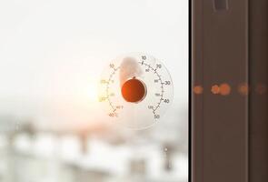 Rays of the sun against the background of a street thermometer with a snow cap. The concept of frosty weather and cooling in winter. Copy space for text, dependence photo