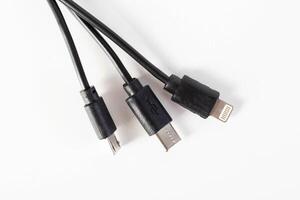Universal black 3 in 1 charging cable with different charging connectors on a white background, close-up. Type-c, usb-c, micro-usb photo