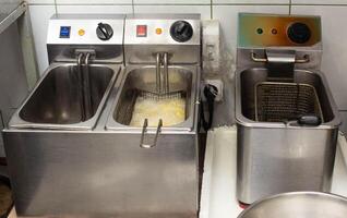 Fryers for roasting potatoes in oil and french fries in the kitchen in the restaurant photo