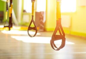 The modern form of fitness and sport loop TRX in the new gym, sunlight, copy space photo