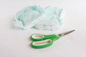 Sliced child pampers and scissors on a white background, diapers photo