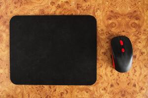 Computer mat and computer mouse on a brown patterned background, close-up, optical photo