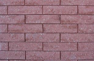 Texture of modern red brick wall with small stones, background photo