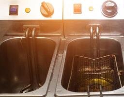 Double deep fryer for cooking french fries, on rustic and slices of potatoes, kitchen, close-up photo