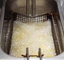Boiling and boiling oil in which fries are fried and rustic in a fast food restaurant, background, cooked, boiling hot photo
