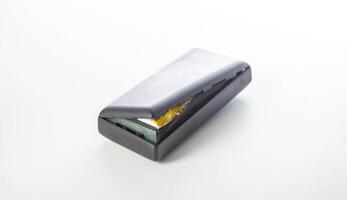 Bloated black power bank on a white background, isolate. Danger of power bank explosion, close-up photo