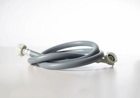 Gray twisted water hose from a washing machine on a white background, isolate, close-up photo