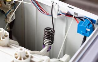 suspension spring of the washing machine tank to dampen vibration when spinning the washing machine. Breakdown and replacement of spare parts, copy space for text photo