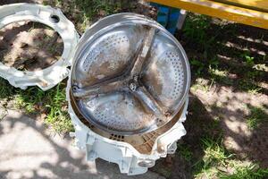 Breakage of the metal cross in the washing machine and non-separable drum. Fault in washing machines, close-up photo