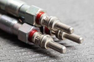 Modern rod ceramic glow plugs for easier starting of a diesel engine in cold weather on a gray background. Automotive spare part, heating element. photo