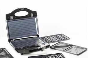 Sandwich maker with baking dishes on a white background, isolate, close-up. Copy space for text photo
