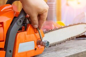 Correct chain tension using the special tool on the chainsaw bar. Chain tension adjustment. photo