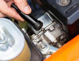 Replacing the spark plug in the motor block engine cylinder. Maintenance of the ignition system. Close-up photo