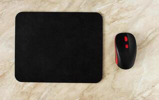 Computer mat and computer mouse on a marble table, close-up, black computer mat photo