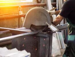 production of pvc windows, a man cuts a profile on a circular saw, close-up, profile photo