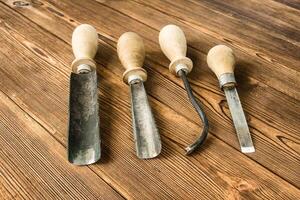 Cutters for wood carving, on a wooden background, close-up, cutting tool photo