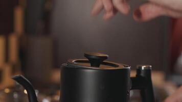 Man closing the lid of a boiling kettle with steam video