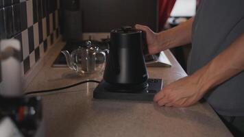 Man putting kettle to boil water in the kitchen video